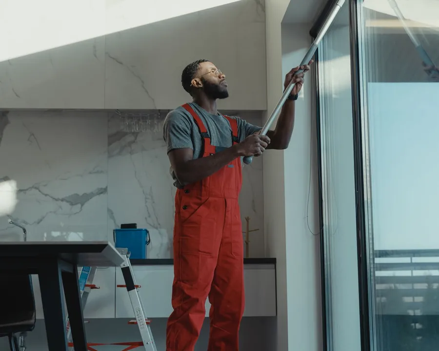 Professional cleaning tall glass with an extension pole